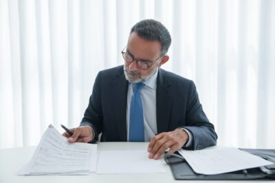 A lawyer sitting at their desk, looking over documents.